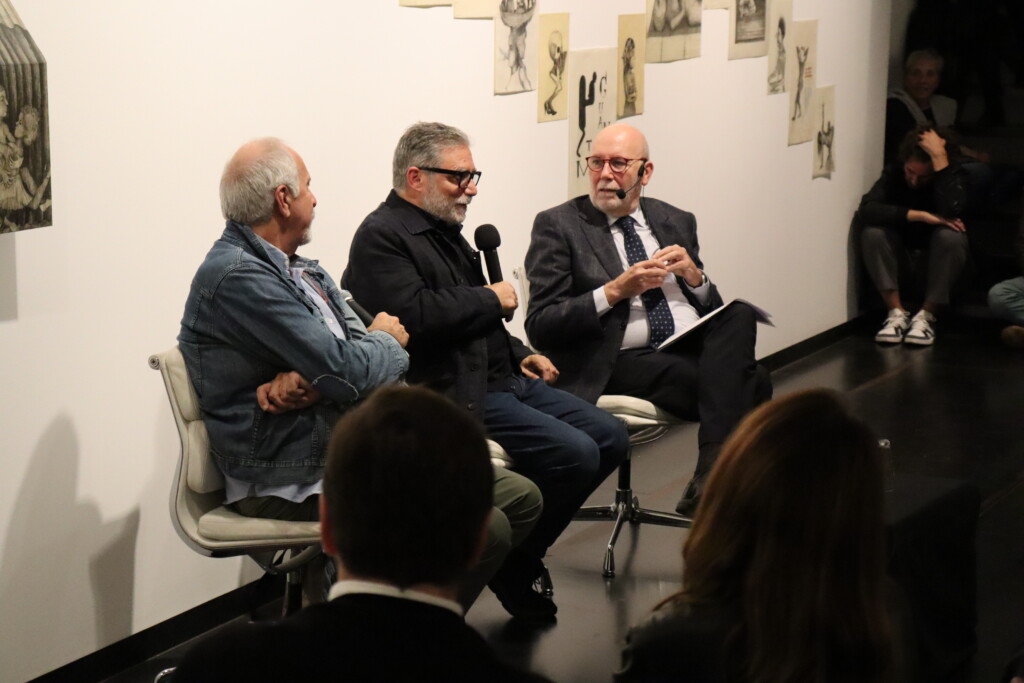 Three men with microphones giving a talk